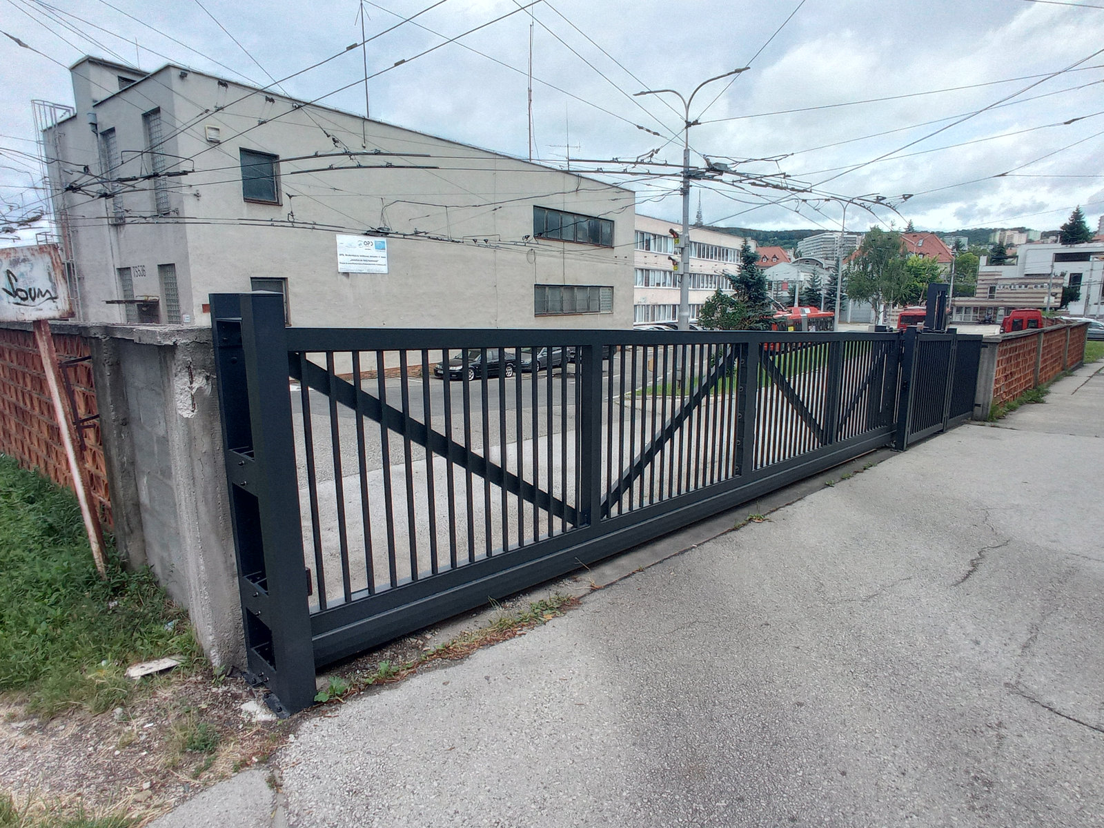 Posuvná brána uzatvárajúca vstup do priemyselného objektu